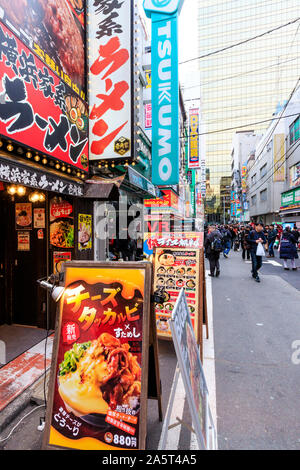 Tokyo, Akihabara Electric Town. Street view lungo Sotokanda con menu a schede sul marciapiede per carni bovine e ramen ristoranti in primo piano. Foto Stock