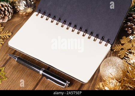 Notebook bianco su uno sfondo di legno con ornamenti Natale decorazioni. Mockup sfondo di Natale con i notebook per la lista dei desideri o elenco di cose da fare. Copia s Foto Stock