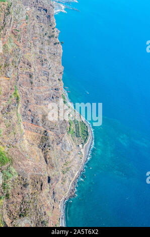 Vista aerea del blu oceano Atlantico e la costa di Madeira. Spiaggia di pietra e campi adiacenti sulla costa meridionale dell'isola di Madeira, Portogallo. Paesaggio di antenna, la splendida natura. Forme naturali. Foto Stock