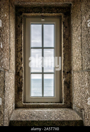 Un verticalview dell'oceano attraverso una finestra di faro in scala di pietra Foto Stock