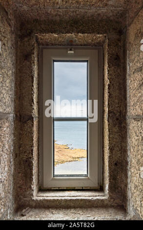 Un verticalview dell'oceano attraverso una finestra di faro in scala di pietra Foto Stock