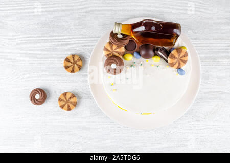 Funny torta con una bottiglia di alcool, caramelle e biscotti sul tavolo di legno Foto Stock
