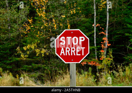 Un rosso e bianco bilingue segno di arresto su un incrocio nelle zone rurali del New Brunswick Canada Foto Stock