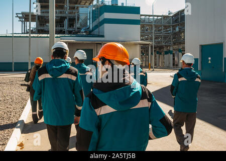 Fabbrica chimica di lavoratori in abiti da lavoro passeggiate per i loro posti di lavoro. Foto Stock