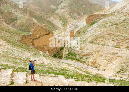 Gli escursionisti passano davanti delle rovine dell antico acquedotto di Wadi Quelt, Prat River Gorge, Governatorato di Gerico, West Bank, Palestina. Foto Stock