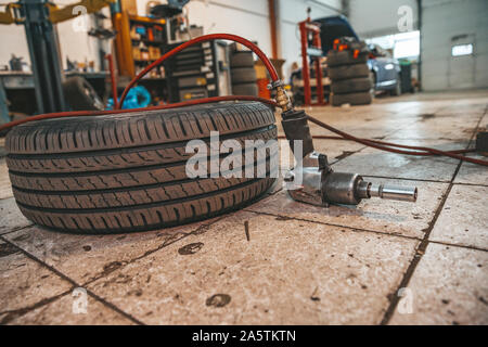 Sostituzione pneumatici invernali su pneumatici estivi in un garage professionale con l aiuto di strumenti professionali. Servizio moderno. Foto Stock