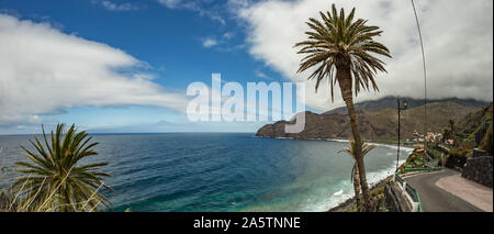 Vista dell'isola di Tenerife da Santa Catalina beach. Enormi pilastri di calcestruzzo per gru e le rovine del vecchio porto Hermigua in background. La G Foto Stock