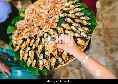 Vassoio di cozze cotte con spezie servito ad una festa gastronomica. Foto Stock