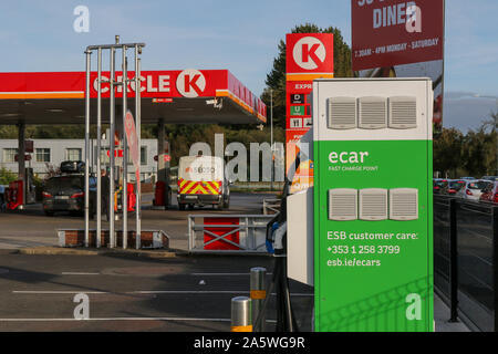 Un auto e punto di carica accanto a una stazione di benzina in Irlanda. ESB fast charge punto accanto a un cerchio K stazione di riempimento benzina. Foto Stock