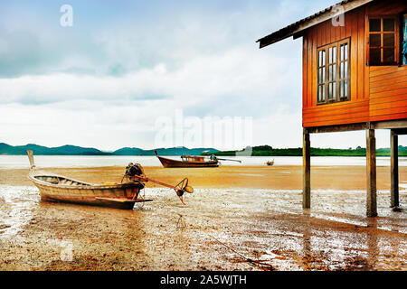 Il rimanente di barche da pesca sulla riva con la bassa marea. Koh Yao Noi, Phuket/Krabi, Thailandia. Foto Stock