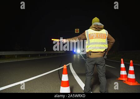 13 ottobre 2019, il Land della Baviera, Wernberg-Köblitz: il poliziotto Alexander Koch devia l'auto a un checkpoint della polizia sulla A93. Foto: Nicolas Armer/dpa Foto Stock