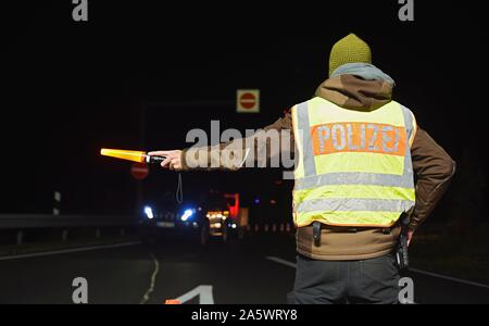 13 ottobre 2019, il Land della Baviera, Wernberg-Köblitz: il poliziotto Alexander Koch devia l'auto a un checkpoint della polizia sulla A93. Foto: Nicolas Armer/dpa Foto Stock