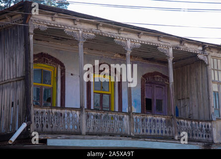 Balcone in legno con ringhiere intagliate e gusci su Windows. Foto Stock