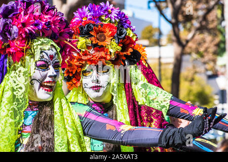 Oct 20, 2019 San Jose / CA / STATI UNITI D'AMERICA - Ritratto di donna con zucchero-cranio make-up, che partecipano al Dia de los Muertos (Giorno dei Morti) processione tenendo Foto Stock