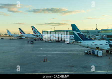 Quattro aerei ormeggiati alle porte dell'aeroporto internazionale Pearson di Toronto. Aeroporto, Terminal 1 durante un bellissimo tramonto. Foto Stock