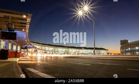 Lunga esposizione di automobili al livello superiore del Terminal 1 e di passaggio all'aeroporto internazionale Pearson di Toronto. Aeroporto durante un bellissimo tramonto. Foto Stock