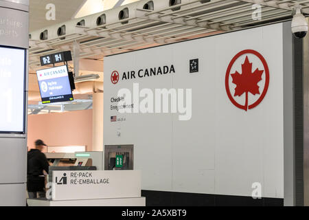 Logo Air Canada accanto a un chiosco per il check-in e il rilascio delle borse all'interno dell'aeroporto internazionale Pearson di Toronto. Aeroporto, Terminal 1. Foto Stock