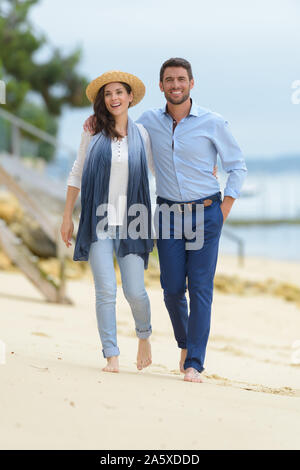 Giovane su un abbigliamento sportivo di camminare sulla spiaggia Foto Stock