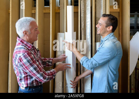 Il cliente nel reparto di legname di hardware store scegliendo il listello in legno Foto Stock
