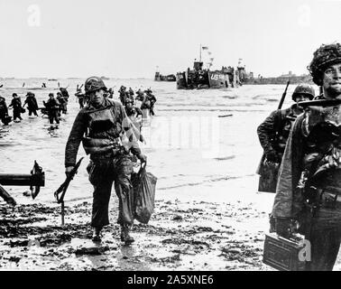 [Didascalia originale] Invasione ... Che trasportano attrezzatura completa, American assalto delle truppe si muovono su di una testa di ponte sulla costa settentrionale della Francia . Landing Craft, in background, marmellate del porto. Giugno 6, 1944. La spiaggia di Omaha. Foto Stock