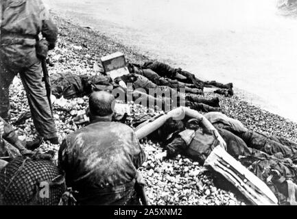 [Didascalia originale] American assalto delle truppe della terza Bat., XVI Regt., 1US Inf. Div., che hanno fallito nel loro tentativo di tempesta attraverso una stretta striscia di spiaggia a Collville Sur Mer, Normandia, per la sicurezza di confronto di un gesso scogliera a poche centinaia di metri dal surf. La spiaggia di Omaha, Francia 6 Giugno 1944 Foto Stock