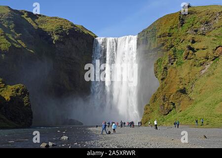 Le persone di fronte alla grande cascata Skogafoss, Skogafoss, Skogar, ring road, Sudurland, Sud Islanda Islanda Foto Stock