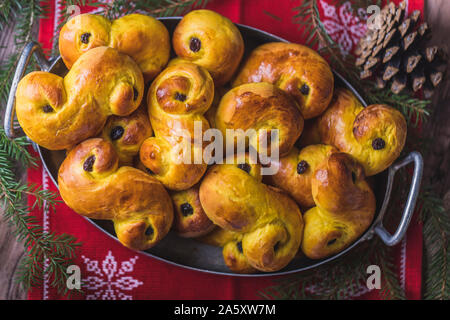 Un vassoio di pane appena sfornato in casa svedese zafferano tradizionali ciambelle, noto anche come lussekatter o lussebullar, visto da sopra. Il giallo panini hanno rai Foto Stock