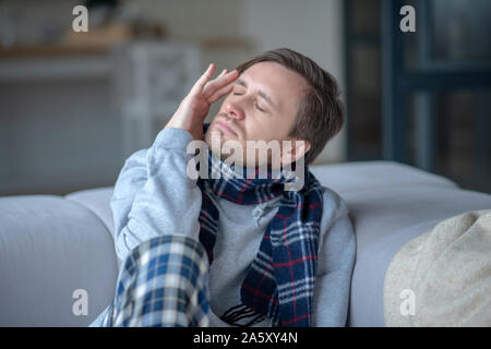 Dai capelli scuri giovane uomo che soffre di un forte mal di testa Foto Stock