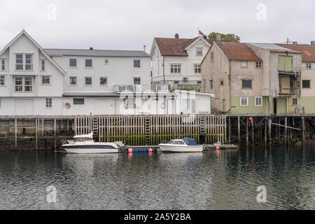 HENNINGSVAER, Norvegia - 13 Luglio 2019: Circolo Polare Artico fjord cityscape del pittoresco villaggio mostra quay con barche da pesca e le tradizionali palafitte Foto Stock