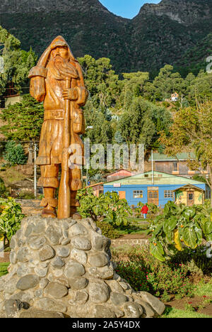 Robinson Crusoe statua su Juan Fernandez isola con l insediamento locale in background, prima dello Tsunami 2010, Cile Foto Stock