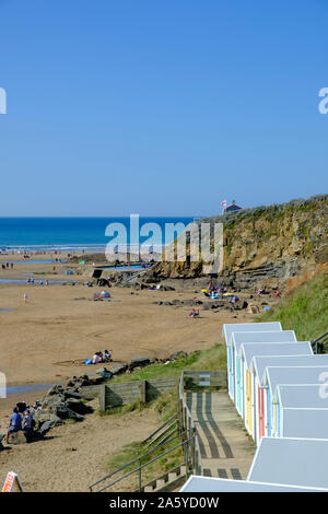 Multi colore capanne sulla spiaggia con il lungomare di fronte alla spiaggia a Bude Cornwall Inghilterra Foto Stock