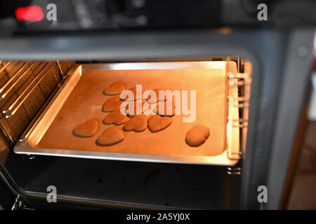 A forma di cuore i biscotti al cioccolato in forno. I cookies dal forno. Foto Stock