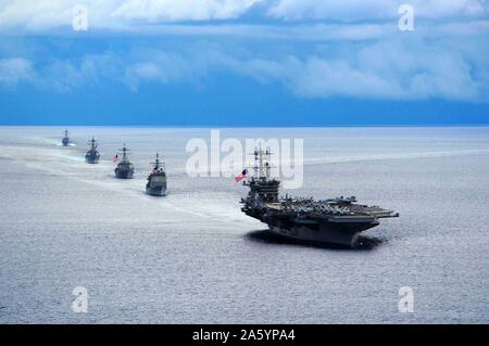 Fotografia di una portaerei USS Theodore Roosevelt leader di una formazione di navi da Gestore Strike gruppo durante un esercizio di manovra. Datata 2014 Foto Stock