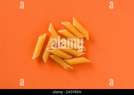 Fresh maccheroni su sfondo arancione. Close up Foto Stock