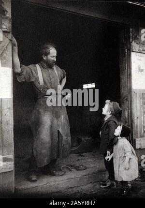 Due bambini parlando a un fabbro in piedi sulla porta della sua fucina. Foto Stock