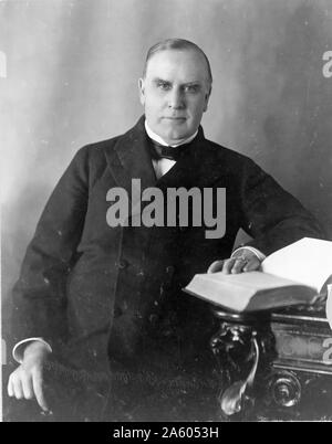 A mezza lunghezza ritratto del presidente William McKinley seduto alla sua scrivania. Durante il suo tempo come presidente ha portato gli Stati Uniti alla vittoria nella guerra ispano-americana e sollevato tariffe protezionistiche per promuovere l'industria americana. Foto Stock