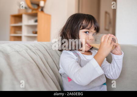 Carino bambina di bere succo di frutta a casa Foto Stock