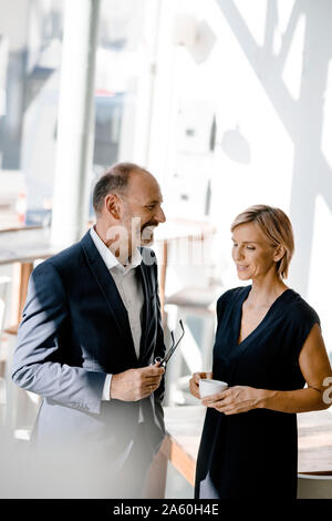 Imprenditore e la donna parlando di soluzioni, bere caffè Foto Stock
