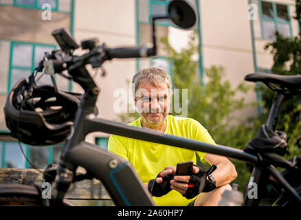 Uomo maturo per una pausa durante il suo tour in bicicletta con un'e-bike Foto Stock