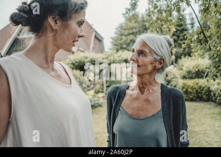 Madre e figlia parlano in giardino Foto Stock