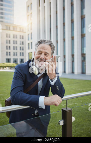 Imprenditore maturo utilizza lo smartphone nella città Foto Stock