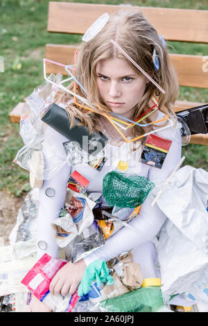 Adolescente indossando abito bianco con i rifiuti plastici, accanto a un Foto Stock