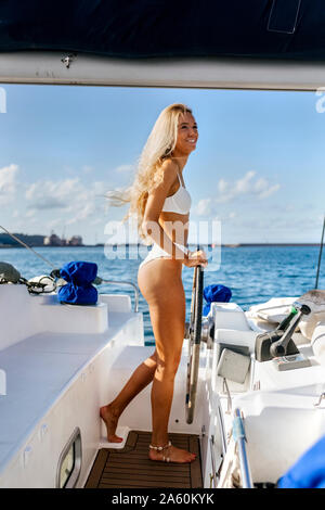 Giovane donna navigazione in catamarano sul un viaggio in barca a vela Foto Stock