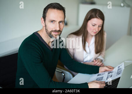 Ritratto di fiducia dell'imprenditore e un dipendente che lavora presso la scrivania in ufficio Foto Stock