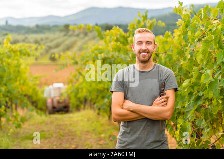 Ritratto di fiducioso giovane nel vigneto Foto Stock