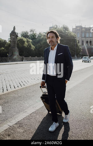 Imprenditore con carrello in città Foto Stock