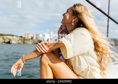 Due belle donne godendo una giornata estiva su una barca a vela Foto Stock