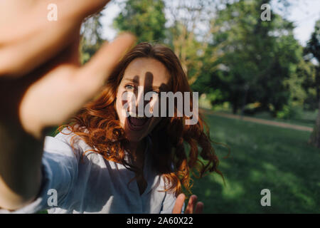 Felice redheaded donna incontro un amico in un parco Foto Stock