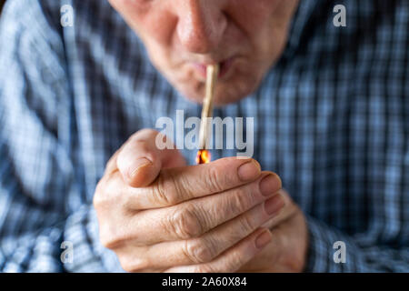 Senior uomo a casa di fumare marijuana joint Foto Stock