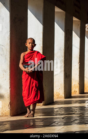 Il debuttante monaco buddista tenendo una ciotola di Shwezigon Pagoda di Nyaung U, Bagan (pagano), Myanmar (Birmania), Asia Foto Stock